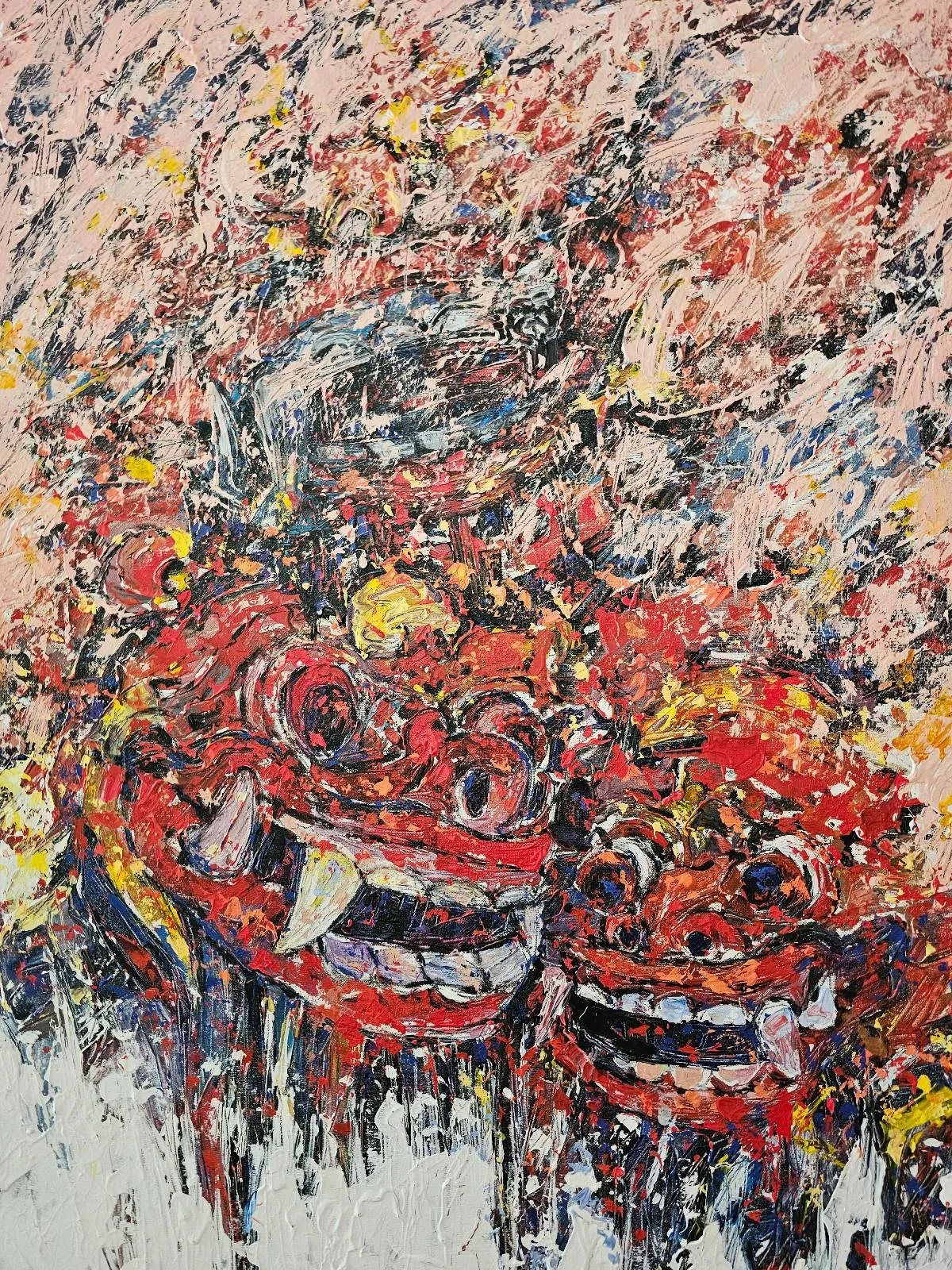 Abstract painting with two red, demon-like faces featuring sharp teeth and large eyes, surrounded by dynamic, chaotic brushstrokes in pink, yellow, black, and white tones. The overall effect is intense and energetic.