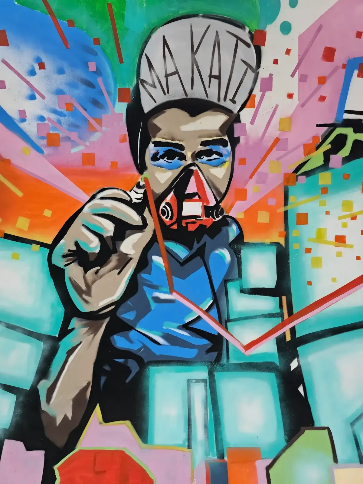 A colorful graffiti mural depicts a person in blue with a hat labeled "MAKATI," pointing forward with vibrant abstract shapes and lines radiating in the background.