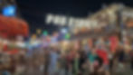 Crowded nighttime scene on Pub Street; people stroll under string lights and neon signs, with vibrant lanterns and a lively, festive atmosphere.