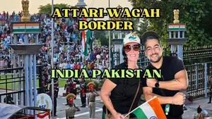 Two tourists posing in front of the daily flag-lowering ceremony at the Atari-Wagah border between India and Pakistan.