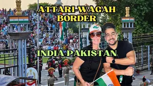 Two tourists posing in front of the daily flag-lowering ceremony at the Atari-Wagah border between India and Pakistan.