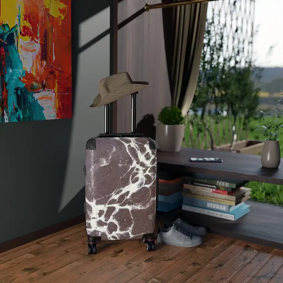 A stylish suitcase with a marbled pattern stands upright in a modern room, with a hat, and a pair of shoes.