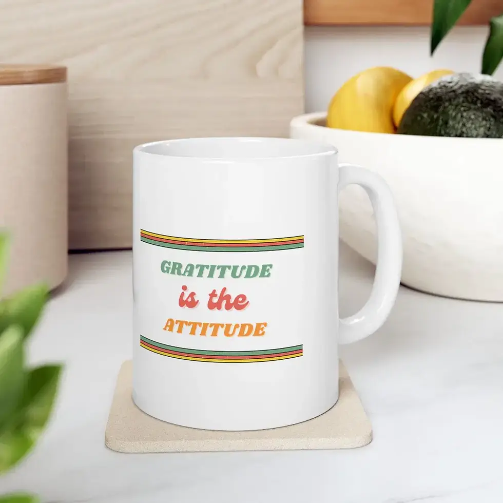 White ceramic mug with retro “Gratitude is the Attitude” text on a kitchen counter.
