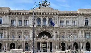 Palace of Justice in Rome with an ornate stone façade, arched central entrance, and statues lining the exterior.