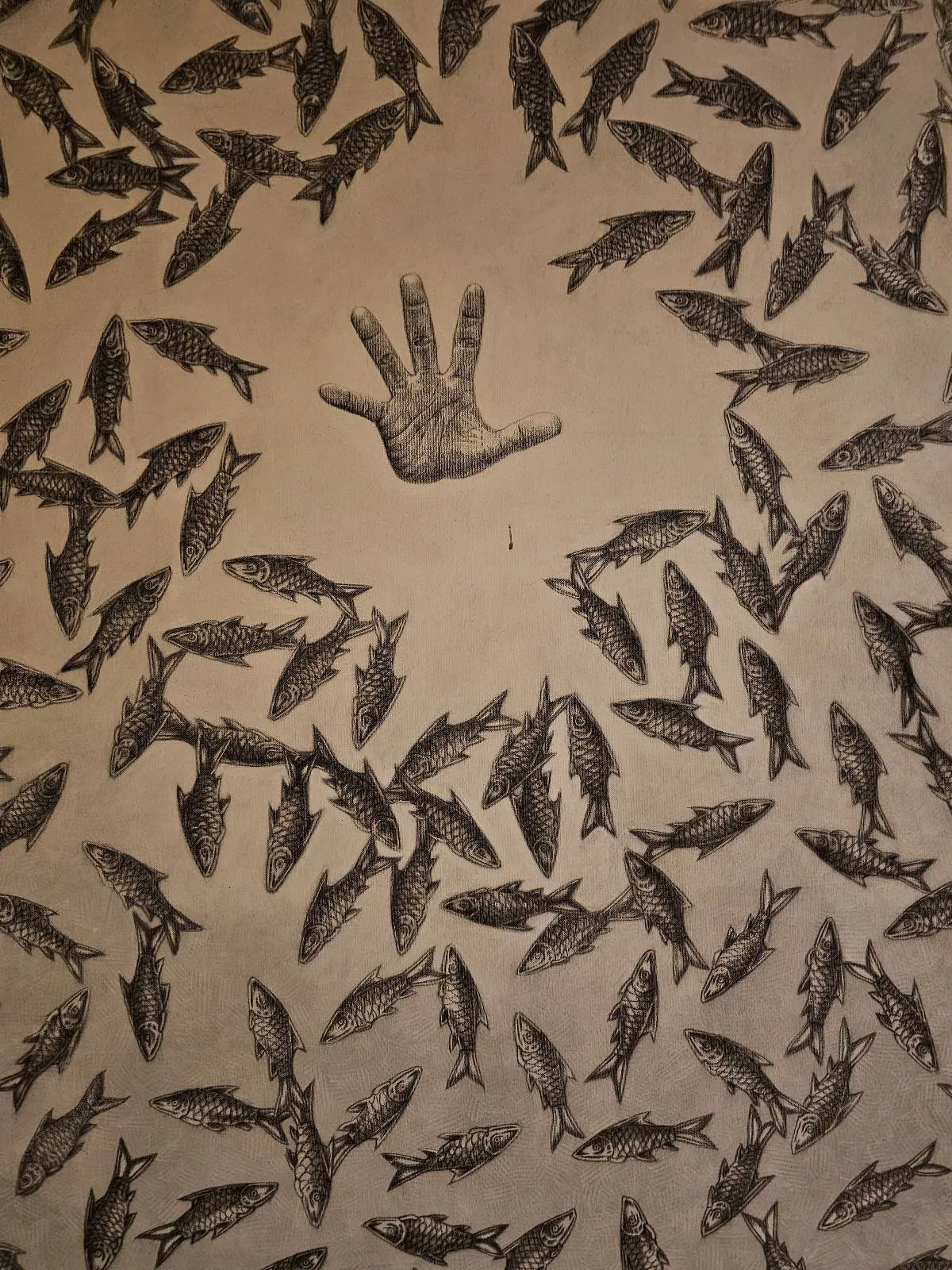 A handprint is surrounded by numerous fish-shaped prints on a light brown surface, creating a pattern with the handprint as the focal point.