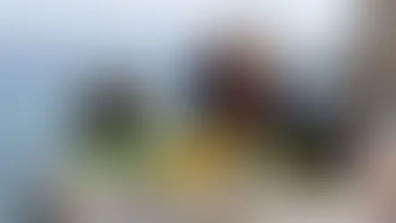 Woman in black dress poses on a rock by the sea, arching back. Text reads "Aphrodite's Rock" over a serene, coastal background.