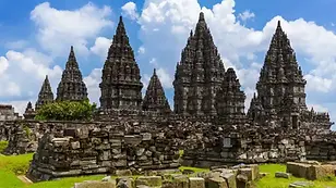Prambanan Temple complex stone towers under blue sky in Yogyakarta, Indonesia.