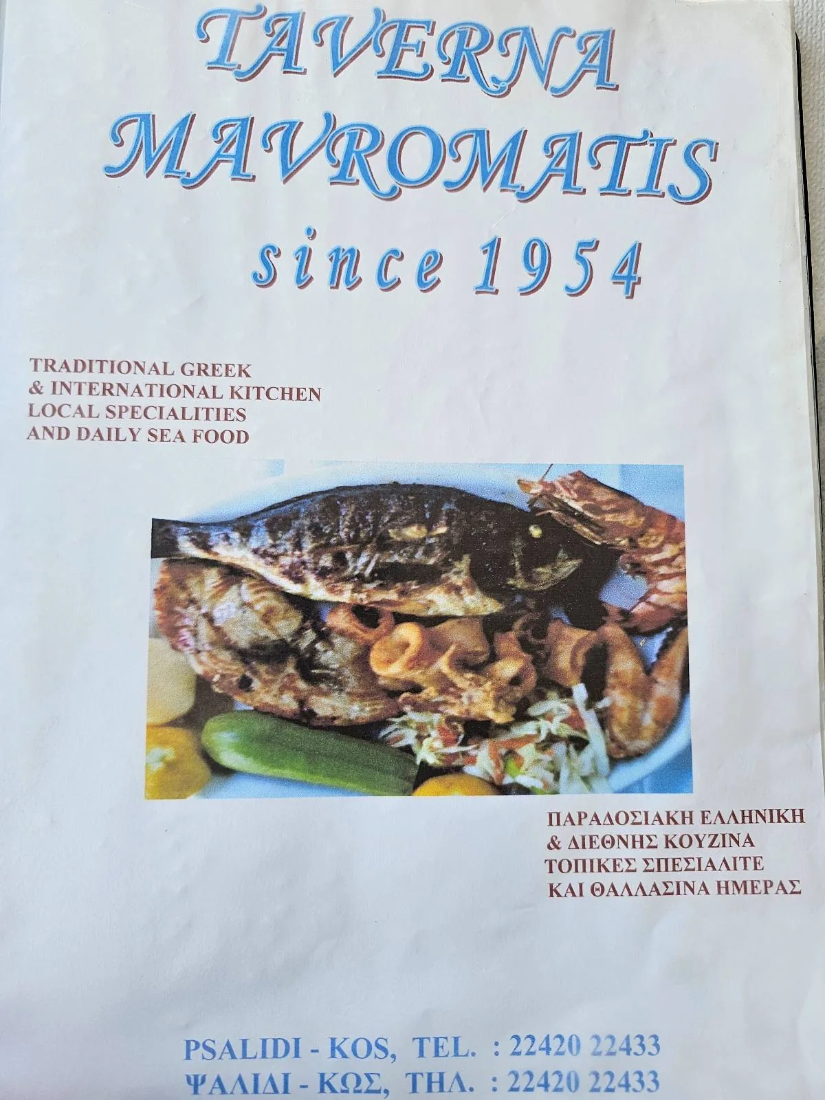 A menu cover for Taverna Mavromatis, established in 1954, featuring Greek text and a photo of grilled seafood with lemon and vegetables. Contact details and restaurant specialties are also included.