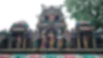 Colorful temple facade with detailed statues of deities in various poses. Ornate carvings with a tree in the background.