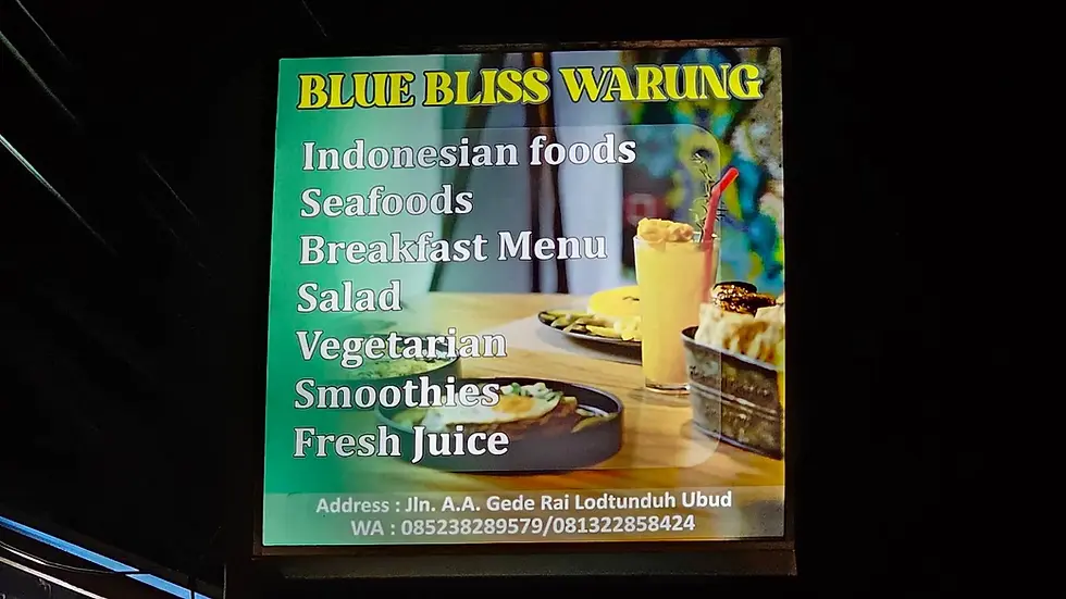 Sign for "Blue Bliss Warung" offering Indonesian foods, seafood, breakfast, salad, smoothies, and more. Includes address and contact info.