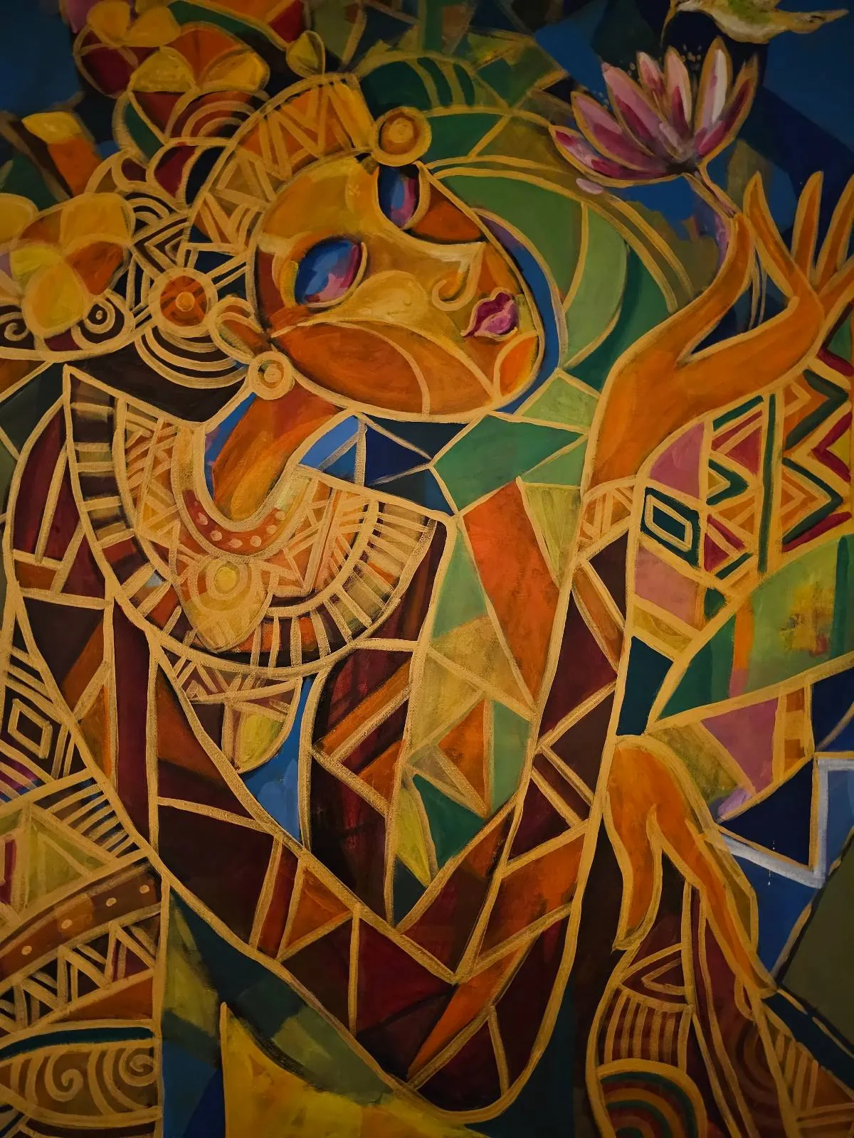 Colorful abstract painting of a person with geometric shapes, wearing ornate jewelry and headdress, holding a pink flower. The artwork features vibrant yellows, blues, and greens with intricate patterns.