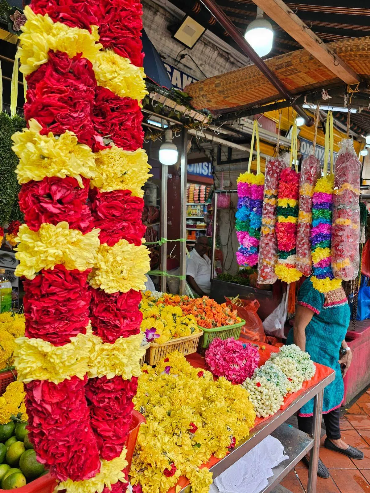 Traditional flower and offering stall with marigold and jasmine garlands in Little India, Singapore.