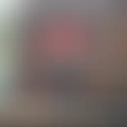 A person practices yoga at the ancient Preah Ko temple in Cambodia. The temple features intricate red-brown stonework.