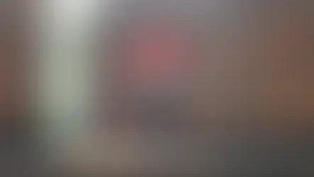 A person practices yoga at the ancient Preah Ko temple in Cambodia. The temple features intricate red-brown stonework.