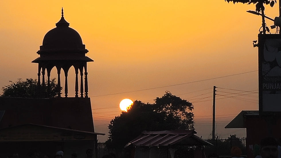 Sunset behind a silhouetted gazebo with an orange sky. Trees and a building with "Punjab" text visible. Calm, serene atmosphere.