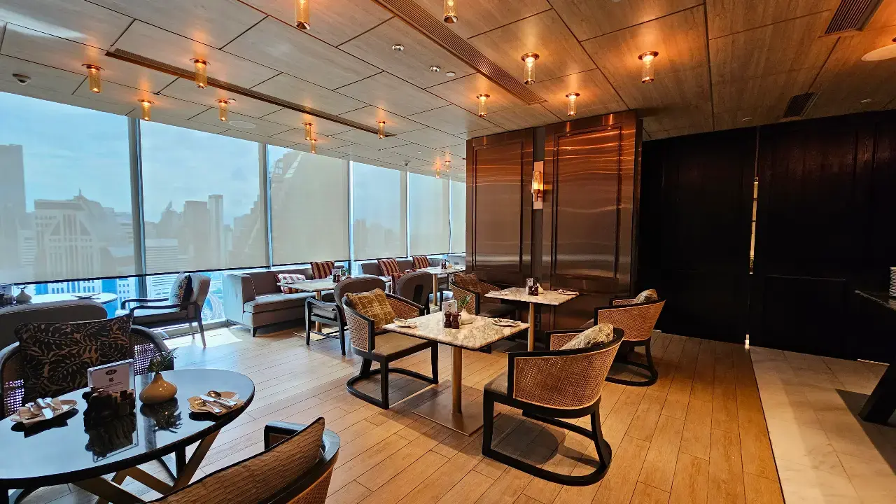 Elegant Regency Club lounge with comfortable seating and floor-to-ceiling windows overlooking Bangkok.