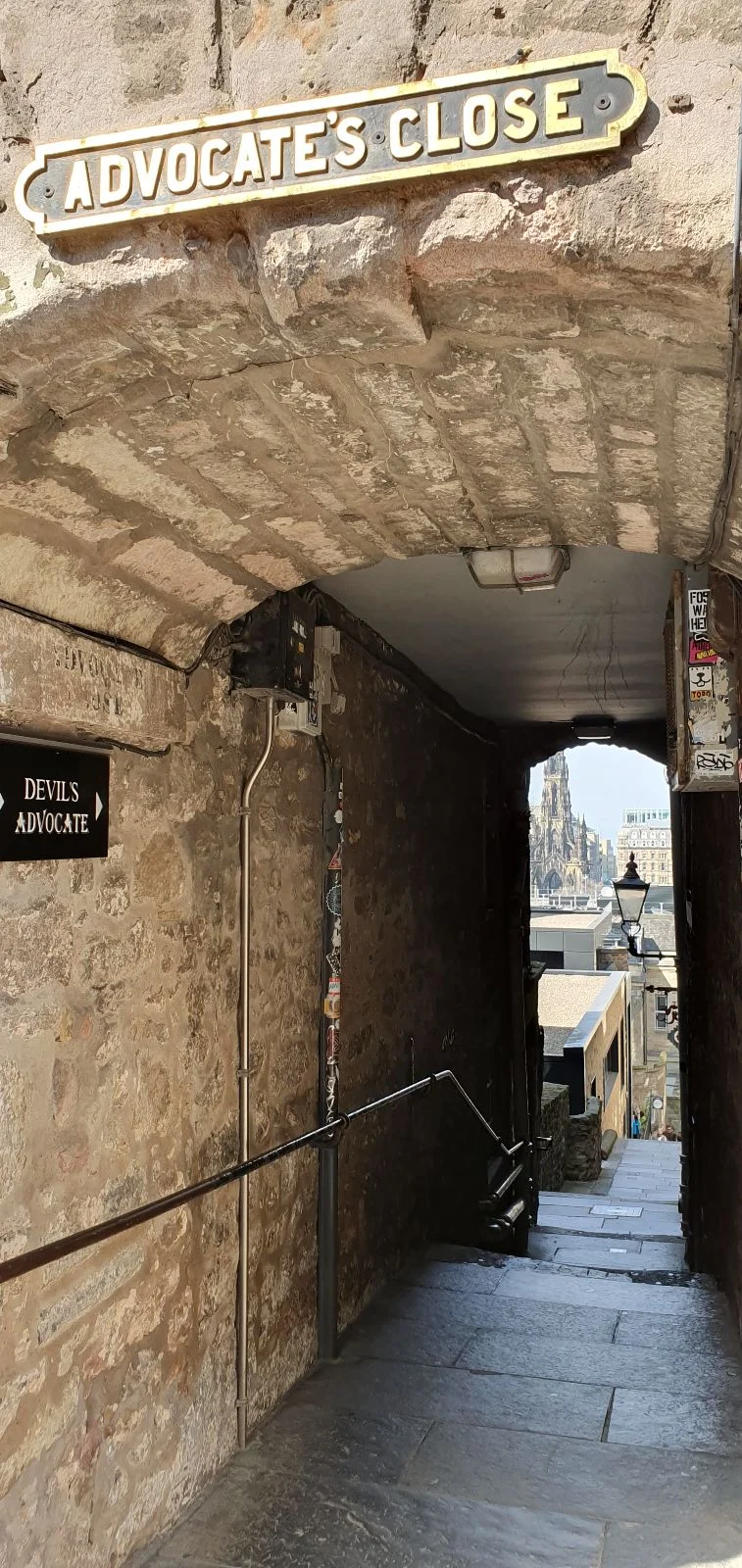 Advocate’s Close in Edinburgh, showing a narrow stone passage with steps leading down toward Scott Monument.