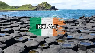 Hexagonal basalt columns of the Giant's Causeway along the rugged Irish coastline, overlaid with the Irish flag and bold text reading "IRELAND".