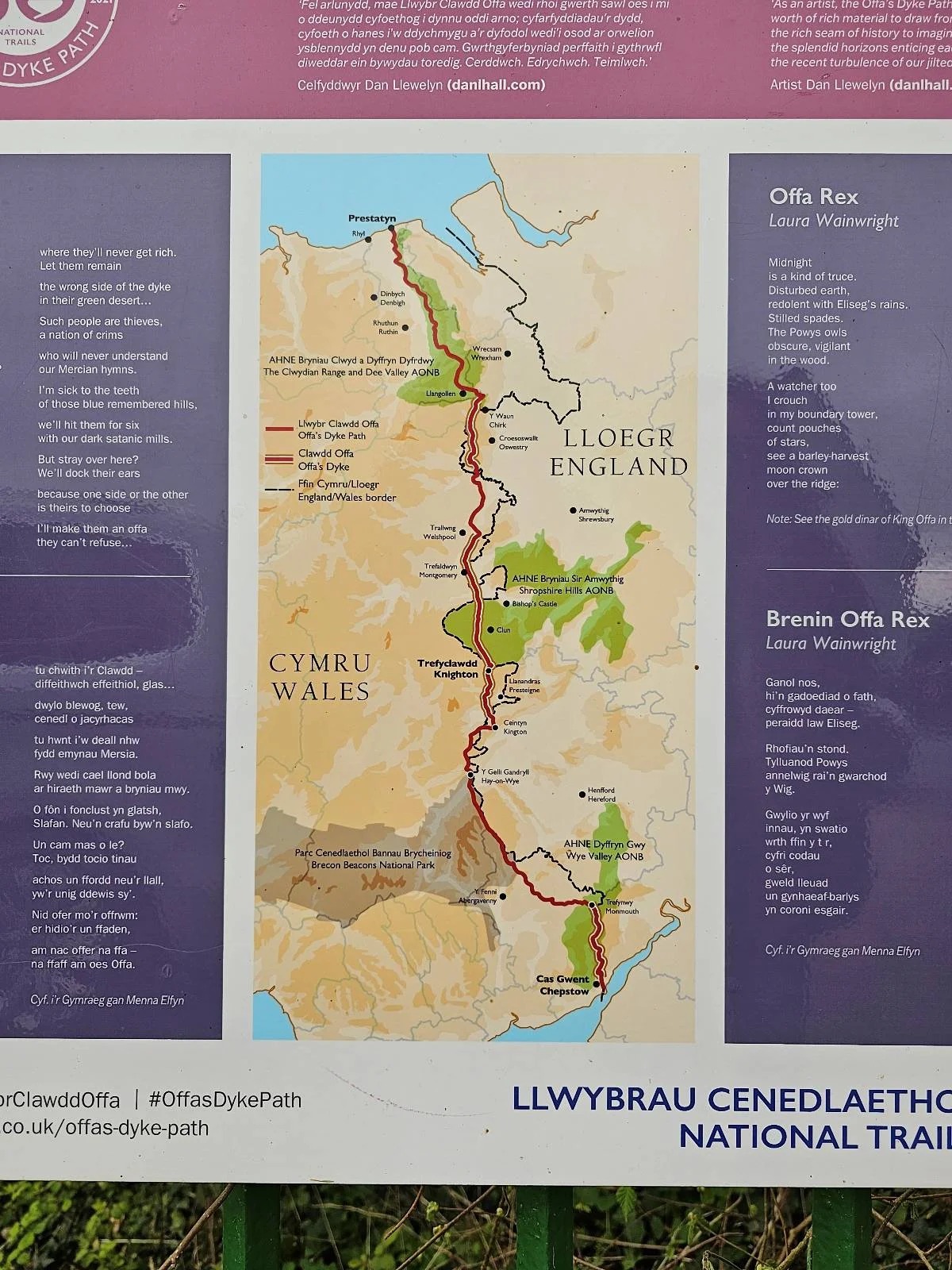 A map showing a section of the Offa’s Dyke Path National Trail, with marked routes, nearby towns, natural areas, and a legend; information panels with text are displayed around the map.