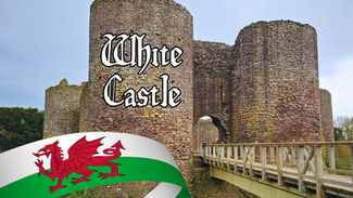 Stone castle with round towers and a wooden bridge. Text "White Castle" in ornate font. Welsh flag with red dragon in foreground.