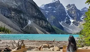 Jenn at Moraine Lake with turquoise water and Rocky Mountains, Alberta, Canada.