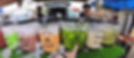 Drink stall with colorful beverage dispensers labeled: Ice Tea, Milo Mix Chocolate, Apple Sour Plum. Hand pointing at Apple Sour Plum.