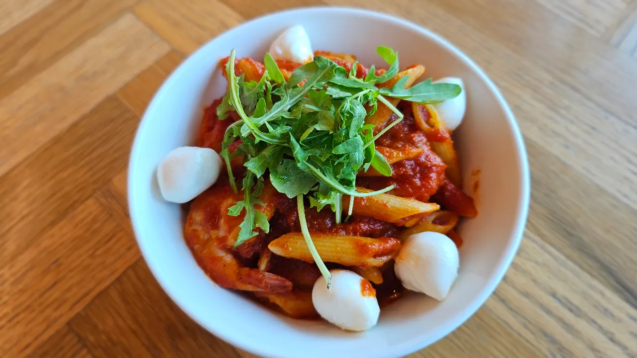 Freshly prepared pasta dish with rich tomato sauce and mozzarella pearls served at Giraffe World Kitchen in Hamad International Airport, Doha, Qatar.