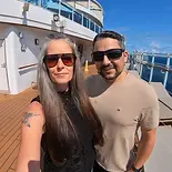 Smiling portrait of co-founders Jenn and Leon together on a boat deck with a clear blue sky background, set in a circular frame.