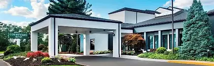 The covered driveway and modern exterior of the Courtyard by Marriott Newark Liberty International Airport in New Jersey, United States.