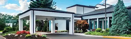 The covered driveway and modern exterior of the Courtyard by Marriott Newark Liberty International Airport in New Jersey, United States.