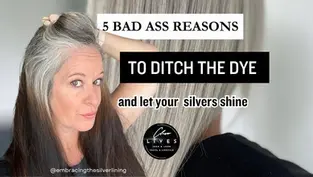 Woman with gray hair touching her head, promoting embracing natural silver hair. Text: "5 reasons to ditch the dye and let your silvers shine!"