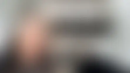 Woman with gray hair touching her head, promoting embracing natural silver hair. Text: "5 reasons to ditch the dye and let your silvers shine!"