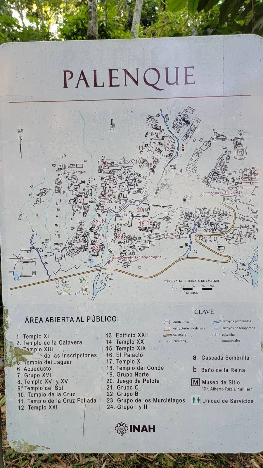 Image of a map displaying the archaeological site of Palenque. It includes a detailed layout with labels and a legend marking open areas to the public. The background shows trees partially visible around the map.