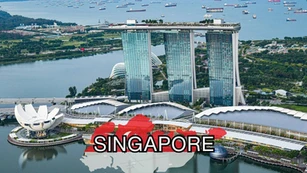 Aerial view of Marina Bay Sands resort in Singapore, with gardens, waterfront, and ships in the bay. “SINGAPORE” is written in bold over a red and white graphic map.