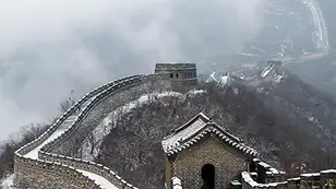 Snow-dusted Mutianyu section of the Great Wall winding across misty mountain ridges.