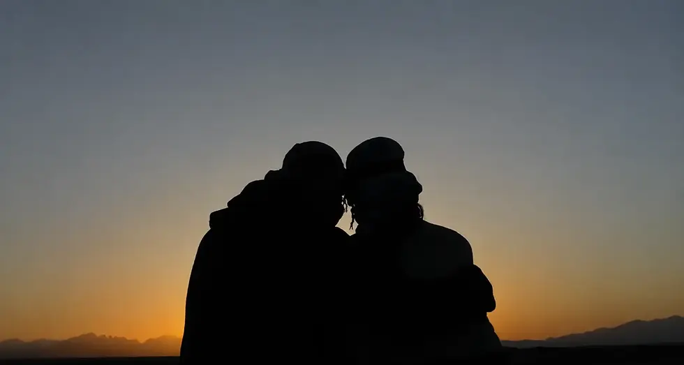 Jenn and Leon silhouetted together against a golden sunset for the Closer Lives travel and lifestyle homepage.