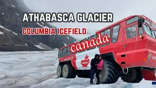 Red ice explorer vehicle with people in winter gear on Athabasca Glacier. Text: Athabasca Glacier, Columbia Icefield, Canada. Snowy background.