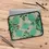 Thumbnail: Laptop sleeve with green floral pattern on wooden surface, closer lives