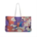 A tote bag with a colorful abstract pattern featuring shades of purple, red, and beige, complemented by white handles.