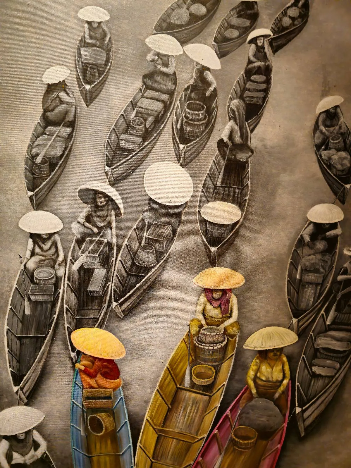 A group of people wearing conical hats sit in wooden boats on water. Most of the image is in black and white, except for three brightly colored boats at the bottom.