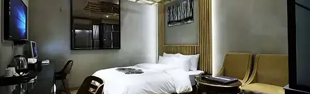A modern, well-lit twin hotel room featuring elegant wooden wall paneling at the Gwangmyeong W Hotel in Gyeonggi Province, South Korea.