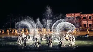 Night performance at Hoi An Memories Show with dancers splashing water on a lit stage.