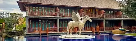 A beautiful outdoor pool area featuring a large white horse statue at The Chaya Resort And Spa in Chiang Mai, Thailand.