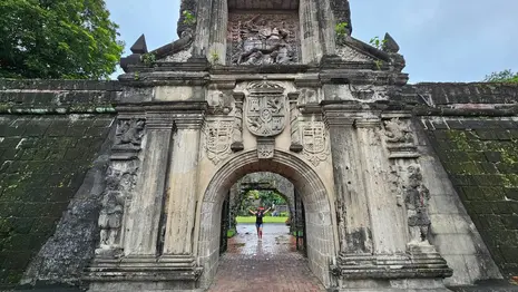Stone entrance gate of Fort Santiago with carved crest and arched doorway in Intramuros, Manila.