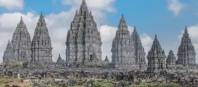 The ancient stone spires of the Prambanan Temple complex, featuring intricate carvings and towering Hindu architecture against a blue sky with scattered clouds.