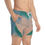 Thumbnail: A person wearing swim trunks featuring a fast-drying teal and cream marble pattern stands with one hand in the pocket.