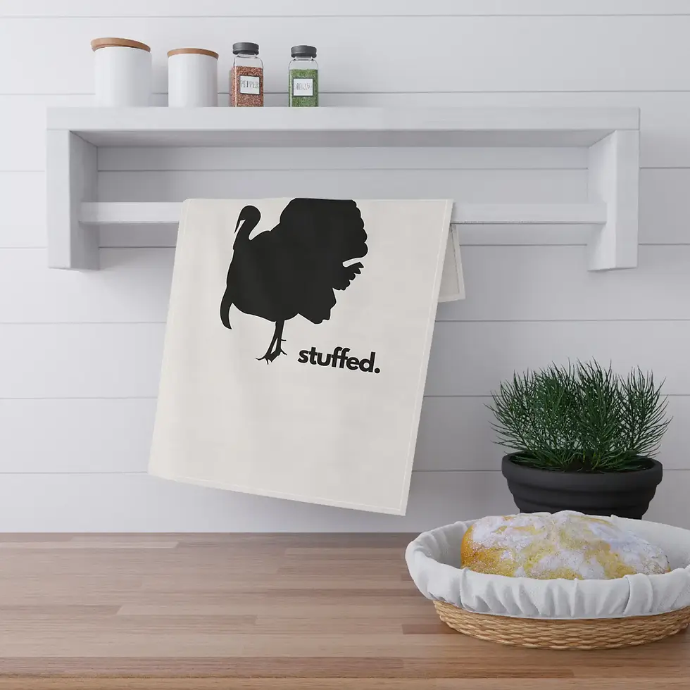 A kitchen scene featuring a white towel with a black silhouette of a turkey and the word "stuffed" hanging on a rack.
