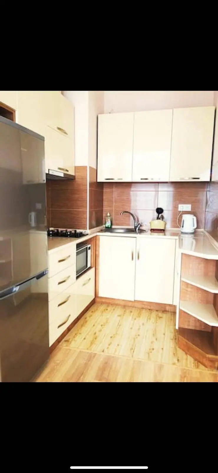A small kitchen space with cream colored units.
