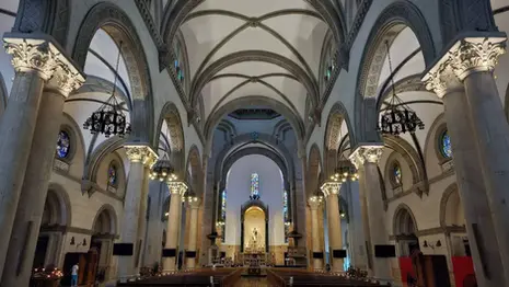 Interior of Manila Cathedral with arched ceiling, columns, altar, and stained glass windows.