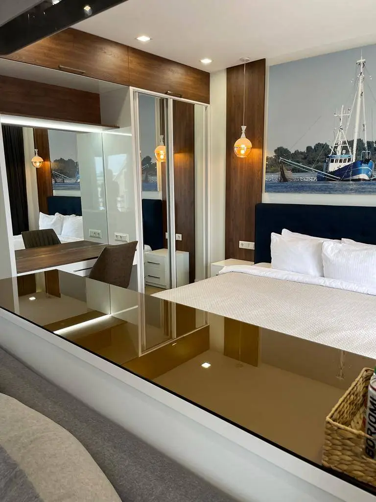 A bed next to a wardrobe with full length mirrors.